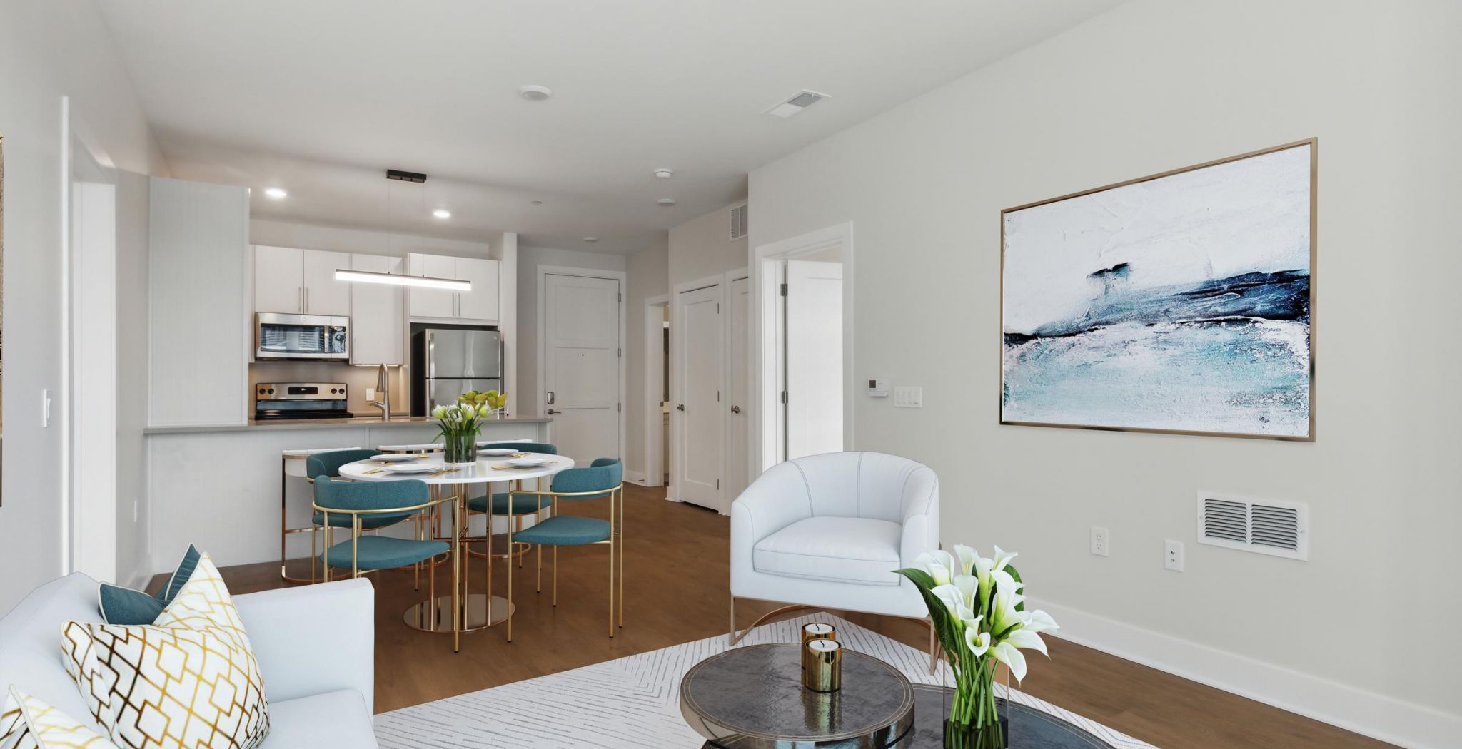 Modern open-plan living and dining area with blue chairs, a round table, and abstract wall art.