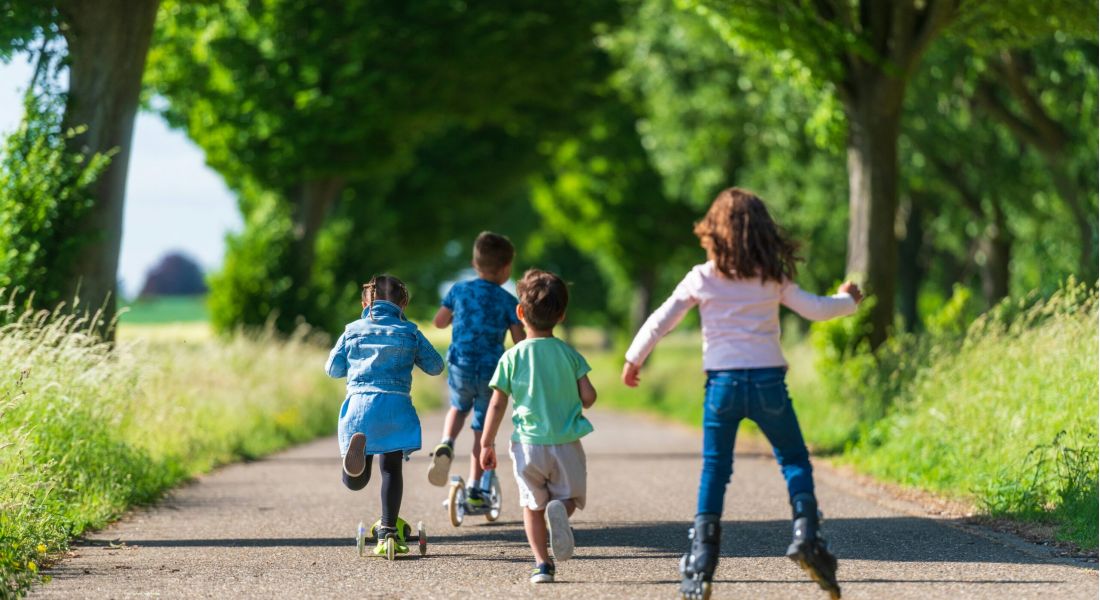 Middle aged woman walking a bike near a park
